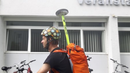 Cyclist with Leica’a GPS antenna attached to the backpack
